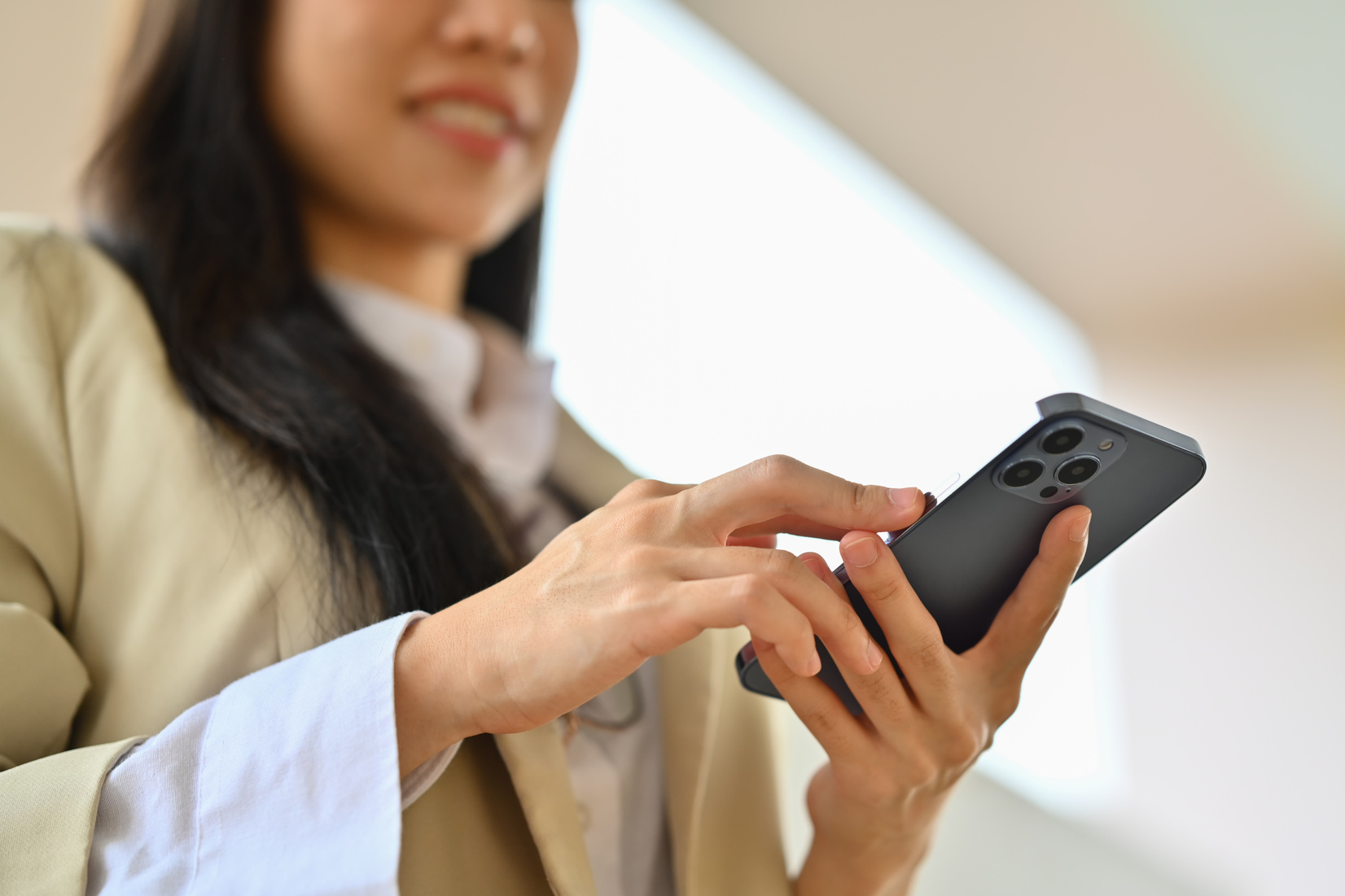 Smiling businesswoman texting messages, chatting in social on smartphone